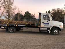 Hoist Towing & Recovery moving Cargo on Flatbed of Tow Truck
