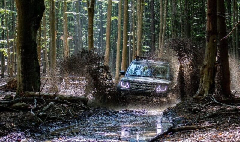 Off-road vehicle rocking back and forth on a muddy forest trail