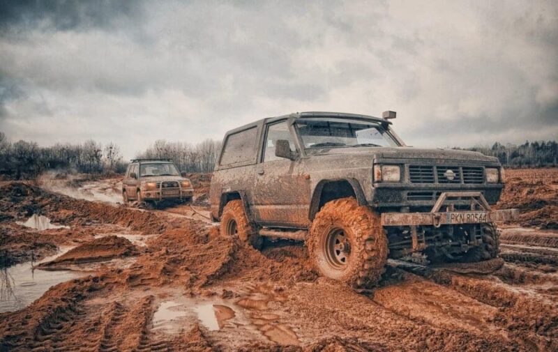 4x4 vehicle pulling another vehicle out of deep mud and water