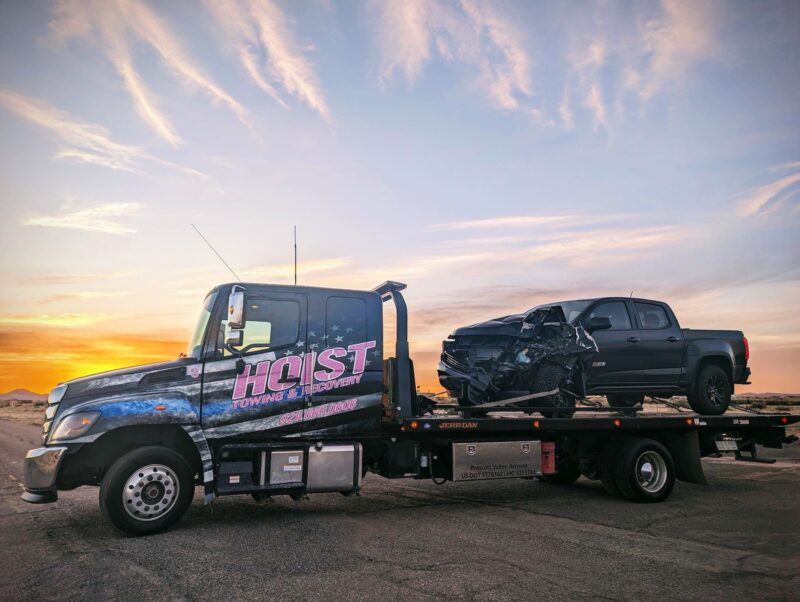 Hoist Towing flatbed truck providing accident recovery towing for a damaged Z71 truck front end