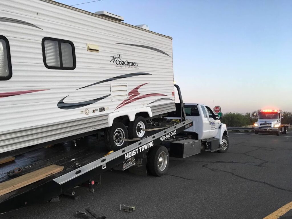 Recreational Vehicle Towing of a Travel Trailer loaded on Hoist Towing Flatbed Tow Truck