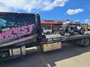 Hoist Towing Three Wheel Motorcycle Towing Hoist Towing motorcycle towing service transporting a three-wheel motorcycle on a flatbed tow truck.