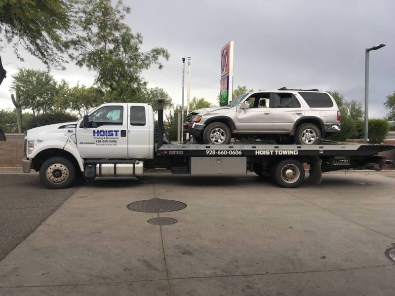 An SUV with front end damage is loaded onto our truck bed providing emergency accident towing services.